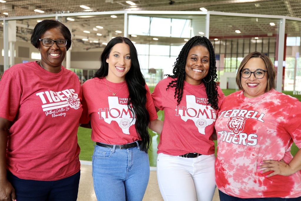 A group of 4 multi-racial women smiling in red shirts